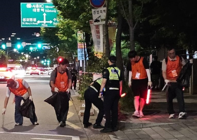 한화 임직원 봉사단이 5일 불꽃축제 행사 후 여의도 한강공원 일대의 쓰레기를 줍고 행사장을 정리하는 ‘클린 캠페인’을 펼치고 있다. 한화 제공