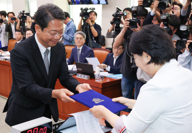 김승원 법무부 장관 후보자가 15일 국회 법제사법위원회에서 열린 인사청문회에서 법사위원장인 더불어민주당 서영교 의원에게 선서문을 제출하고 있다. 연합뉴스