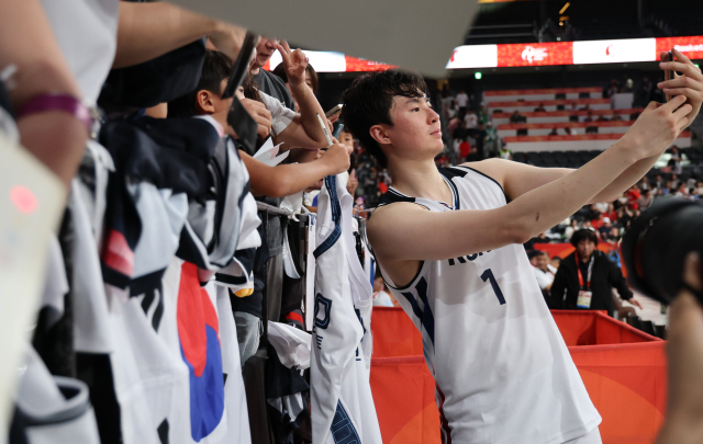 18일 일본 나고야 아이치 인터내셔널 아레나에서 열린 2026 아이치·나고야 아시안게임 남자 농구 대한민국 대 이란 4강전. 승리한 대한민국의 이현중이 팬들과 기념촬영을 하고 있다. 연합뉴스