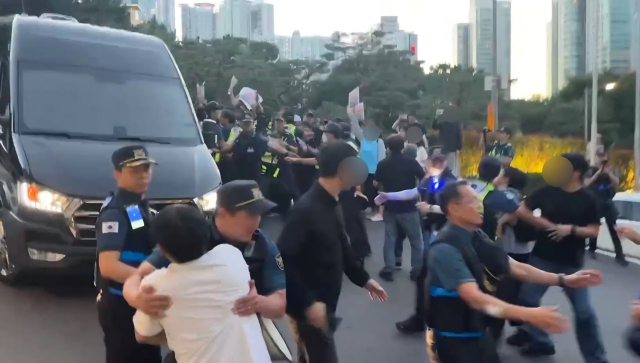 부산자주통일평화연대(이하 평화연대)는 지난 16일 오후 5시부터 17일 오전 9시까지 해운대구 우동 A호텔 앞에서 ‘호르무즈 파병 협박 미국 협상단 규탄 철야행동전’을 열었다. 사진은 평화연대 측이 한미 통합국방협의체 미국 협상단 차량의 숙소 진입을 가로막는 모습. 평화연대 제공.