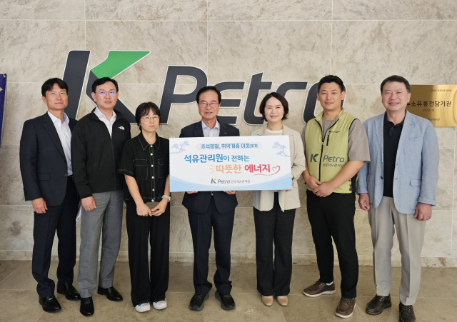 나눔행사 팻말을 들고 있는 최춘식 한국석유관리원 이사장(왼쪽 네 번째)과 성남시지역아동센터연합회 회장. 석유관리원 제공