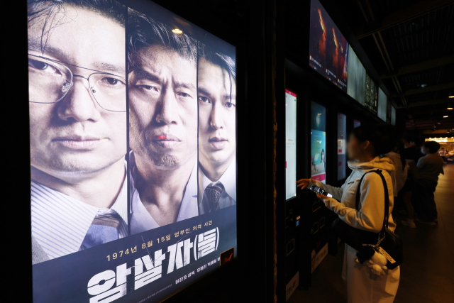 육영수 여사 피격 사건을 다룬 영화 ‘암살자(들)’을 둘러싼 논란이 확산하면서 오는 5일 예정된 부산 무료 시사회도 취소됐다. 사진은 서울의 한 영화관에 걸린 영화 포스터. 연합뉴스