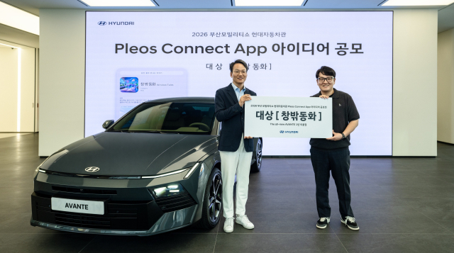 현대차 이철민(왼쪽) 국내마케팅실장(상무)와 ‘플레오스 커넥트 앱 아이디어 공모전’ 대상 수상자 정이든 씨가 1년 이용권으로 제공 받은 디 올 뉴 아반떼 옆에서 기념촬영을 하고 있다.현대차 제공
