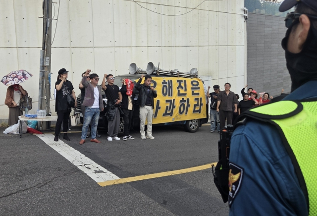4일 서울 성북구에 있는 영화 '암살자(들)'의 주연 배우 유해진 자택 앞에서 보수단체 회원들이 제작사와 배우를 규탄하는 집회를 하고 있다. 연합뉴스