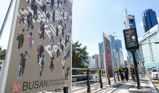제31회 부산국제영화제(BIFF) 개막을 하루 앞둔 5일 부산 해운대해수욕장 앞에 설치된 영화제 관련 포스터 앞으로 시민들이 지나가고 있다. 김종진 기자 kjj1761@