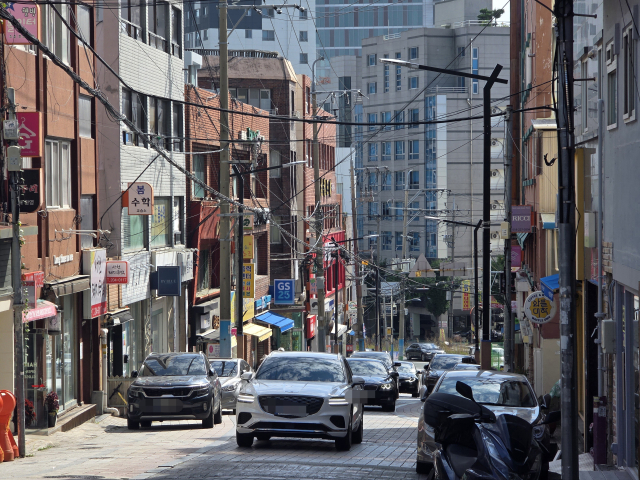 지난 11일 오전 부산 사하구 하단동 낙동대로 516번길 일대. 좁은 이면도로에 설치된 전신주와 주차 차량이 시민들과 차량 이동을 방해해 사고 위험이 우려된다. 인근 동아대학교 승학캠퍼스와 부산여자고등학교 재학생 안전을 위해 전선 지중화 사업이 추진되고 있지만 사하구청 예산 부족으로 사업이 시작되지 못한 상태다. 김재량 기자 ryang@