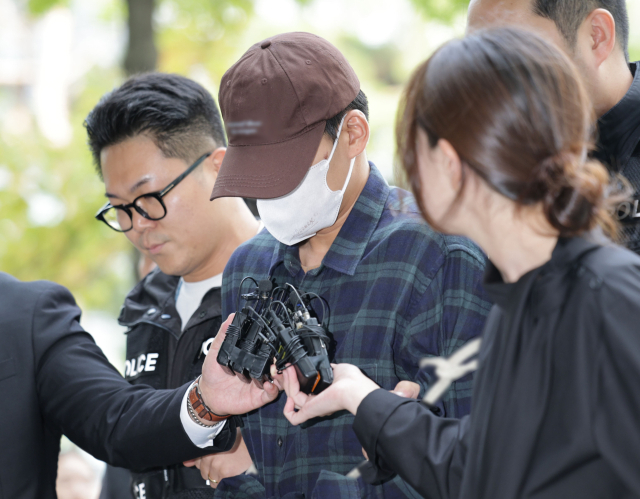 이혼소송 중 장모 살해 및 아내를 납치한 20대 중반 남성 A 씨가 13일 서울 송파구 서울동부지방법원에서 열린 구속 전 피의자 심문(영장실질심사)에 출석하고 있다. 연합뉴스