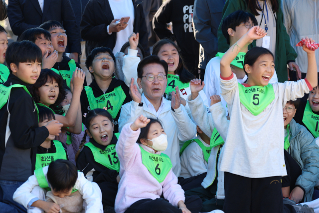이재명 대통령이 22일 전북 익산 왕궁초등학교에서 열린 가을 체육한마당에서 학생들과 응원을 하고 있다. 연합뉴스